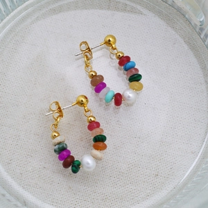 Macro detail of multi-colored beaded earrings with pearls and gold brass accents