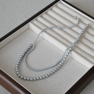 Detail of double-layer pearlescent gray bead necklace with silver lobster clasp