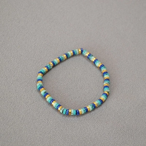 Macro shot of turquoise beads and golden spacers on a flexible bohemian beaded bracelet