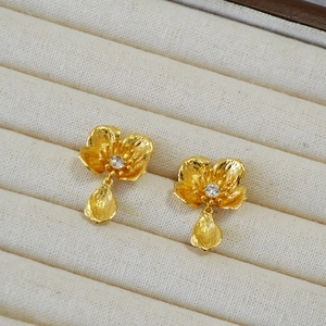 Macro shot of 925 silver vintage flower earrings with gold finish and zircon center