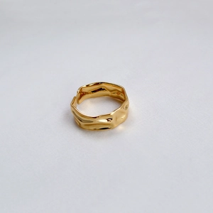 Vue détaillée d'une bague en laiton doré avec une texture de lave irrégulière polie
