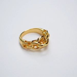 Détail d'une bague en laiton doré avec texture de maille gourmette et anneau poli