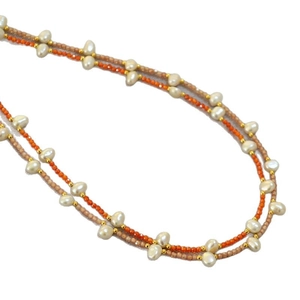 Double-layered beaded necklace with orange seed beads and baroque pearls on white background