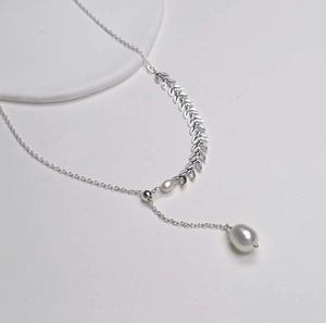 Vue détaillée d'un collier feuille argenté orné de perles rondes et en forme de goutte
