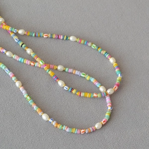 Detail macro view of bohemian necklace with colorful heishi beads and white pearls