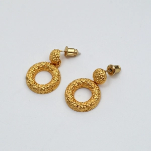Macro shot of gold-plated brass earrings featuring hammered texture and hollow circles