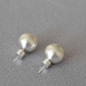 Vue détaillée de boucles d'oreilles sphériques argent mat avec texture métal brossé