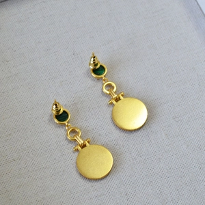 Macro shot of gold-plated Egyptian cat coin earrings with malachite stones and 925 silver pins