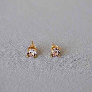 Detailed close-up of gold stud earrings with round champagne crystals in 4-prong setting