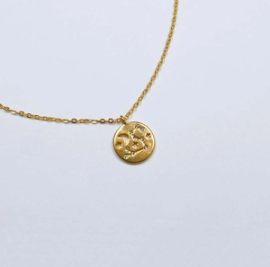 Vue détaillée du collier en laiton doré avec pendentif céleste lune et étoiles design