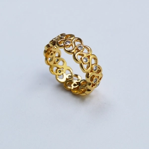 Détails macro d'une bague vague en laiton doré ornée de pierres de zircone cubique
