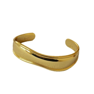 Minimalist C-shaped open gold brass bangle with polished edges and matte finish texture