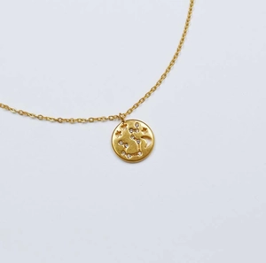 Détail du pendentif pièce plaqué or avec motif étoilé ajouré et pierres de zircon