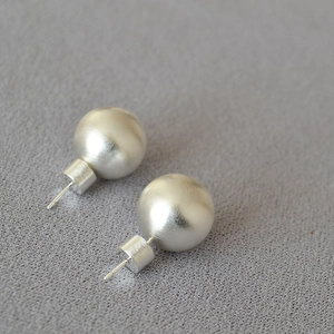 Détail macro de boucles d'oreilles sphériques en argent avec texture métallique brossée