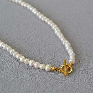 Detail of elegant baroque freshwater pearl necklace featuring a golden OT toggle clasp