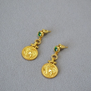 Detail of vintage brass gold coin earrings with malachite and leopard relief