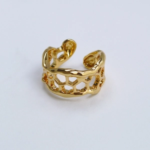 Vue détaillée du motif organique en nid d'abeille sur une bague en laiton plaqué or