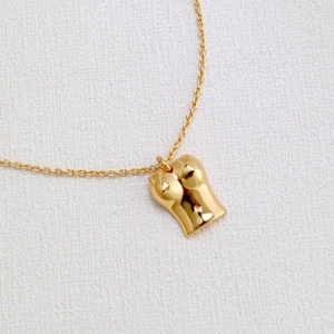 Gros plan détaillé du collier en laiton plaqué or avec pendentif buste de femme poli