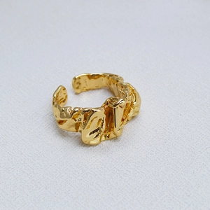 Détail macro de la texture lave et de l'anneau ajustable sur cette bague en laiton doré