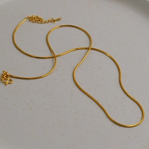 Détail d'un collier chaîne serpent en laiton plaqué or avec fermoir ajustable élégant