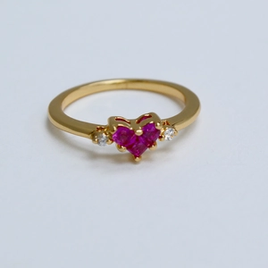 Gros plan sur la bague en plaqué or avec cœur en pierres roses et petits diamants blancs