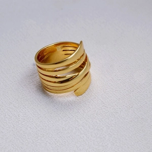 Détail d'une bague multicouche en laiton plaqué or avec un design en spirale poli