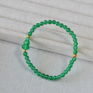 Dettaglio del bracciale di agata verde con ciondolo a zucca e perline in metallo oro