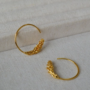 Detail view of gold-plated brass hoop earrings with elegant wheat ear texture design