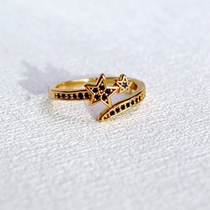 Détail macro d'une bague en laiton doré avec motif double étoile en zircon bleu
