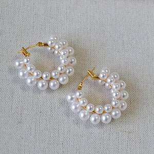 Close-up of elegant French vintage pearl hoop earrings with gold metal fasteners