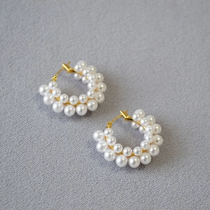 Detail shot of vintage pearl cluster C-shaped earrings with gold metallic framework