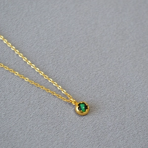 Detail of vintage brass gold coin necklace with green malachite pendant and gold chain