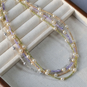 Close-up of multicolored faceted beads and white pearls in a jewelry gift box