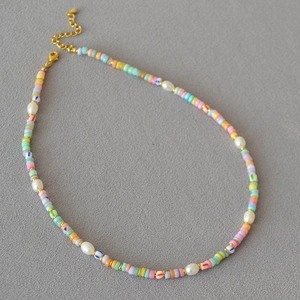 Detail of colorful seed beads and white freshwater pearls on a bohemian necklace chain