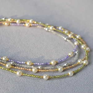 Detail of multi-strand necklace featuring colorful zircon beads and freshwater pearls