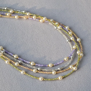 Macro view of multi-layer beaded necklace featuring pearls and colored zircon stones