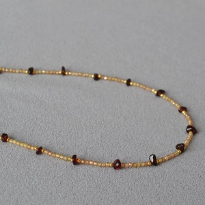 Macro detail of irregular purple amethyst and golden beads on an elegant necklace