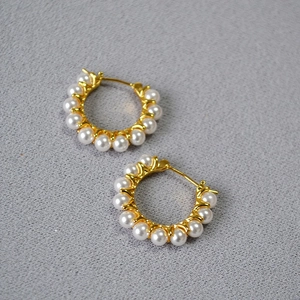 Détails de boucles d'oreilles créoles dorées avec perles blanches incrustées