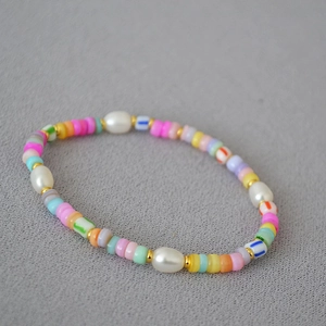 Macro detail of Bohemian beaded necklace with freshwater pearls and colorful ceramic beads