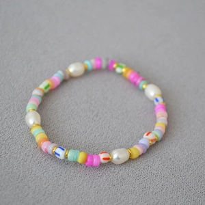 Detail of bohemian necklace with colorful clay beads, white pearls and gold accents