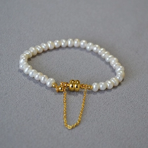 Détail du fermoir magnétique doré et chaîne de sécurité sur bracelet de perles