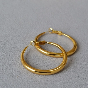 Close-up of polished gold hoop earrings with high-gloss finish and secure clasp closure