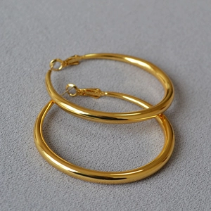 Detailed view of polished large gold hoop earrings with secure click-top closure