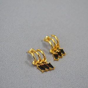 Minimalist gold tassel earrings with black zircon stones in a retro luxury style