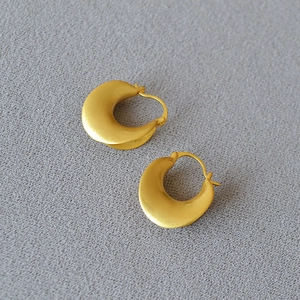 Macro detail of French vintage matte gold hoop earrings with textured lever back closure