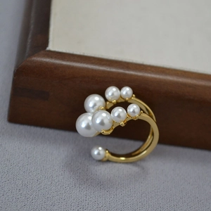 Anello aperto chic in ottone dorato con un gruppo artistico di perle bianche