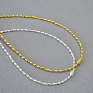 Detail view of gold and silver plated rice bead necklaces with matte texture finish