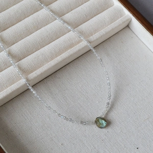 Detail of beaded Labradorite necklace with a faceted teardrop pendant on a display box