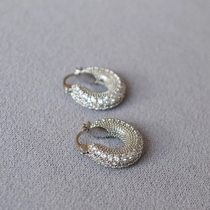 Macro view of silver chunky hoop earrings with full pavé cubic zirconia setting