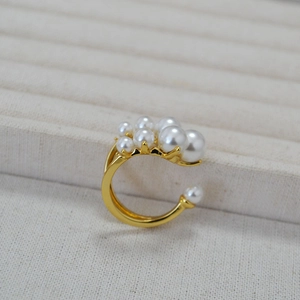 Anello aperto in ottone dorato con perle bianche graduate dal design asimmetrico